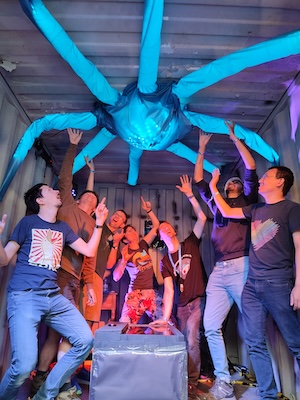 People in a room pointing at an illuminated octopus on the ceiling